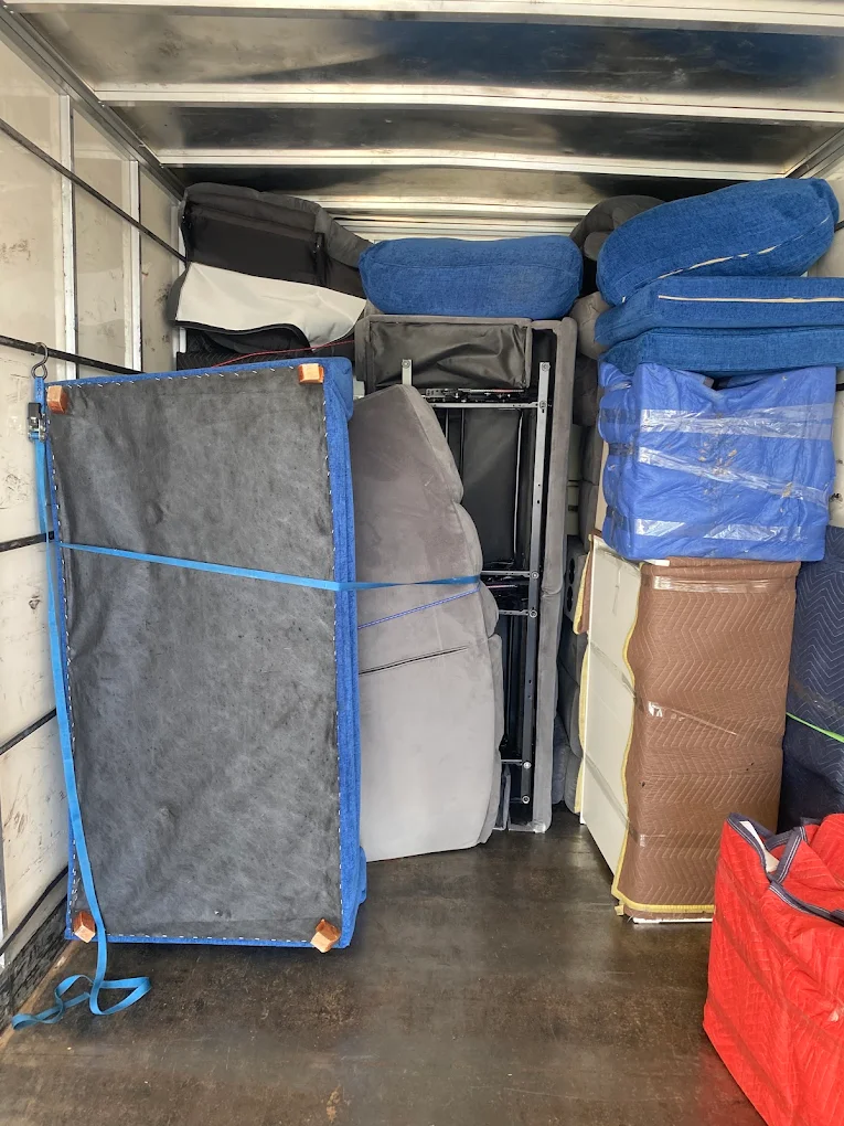 Big Stuff Movers loading a truck with securely wrapped furniture and cushions, showing organized and professional furniture handling.