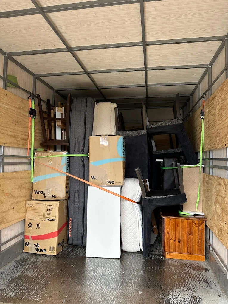 Big Stuff Movers loading and securing furniture and boxes tightly inside a moving truck.