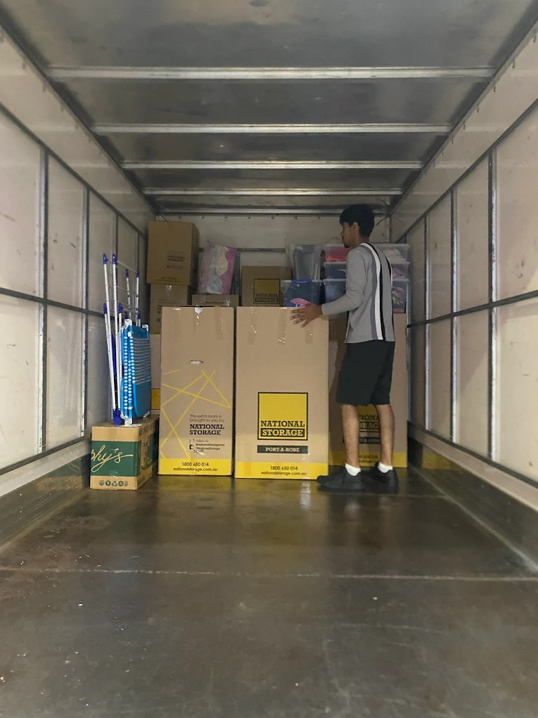 Big Stuff Movers loading boxes and organizing furniture inside a moving truck.