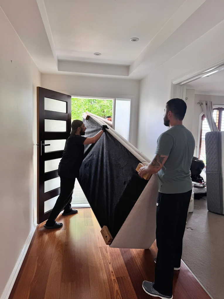 Big Stuff Movers securely loading furniture, boxes, and equipment into a moving truck with straps for safe transport.